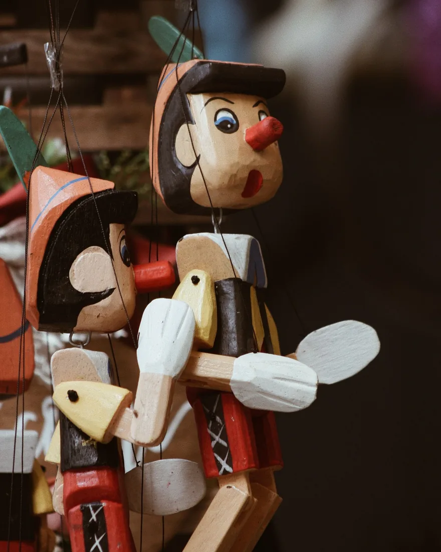 Detalle de marionetas de madera articuladas con sus hilos de manipulación